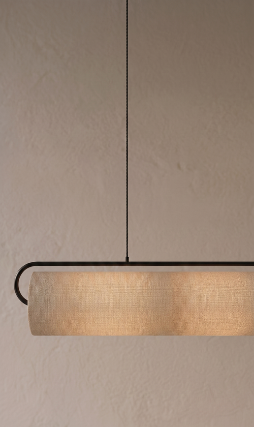 Lámpara colgante lineal Zihua de metal negro y tela iluminando un espacio minimalista - Beu Yani